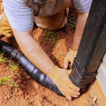 a man is working on a pipe in the ground